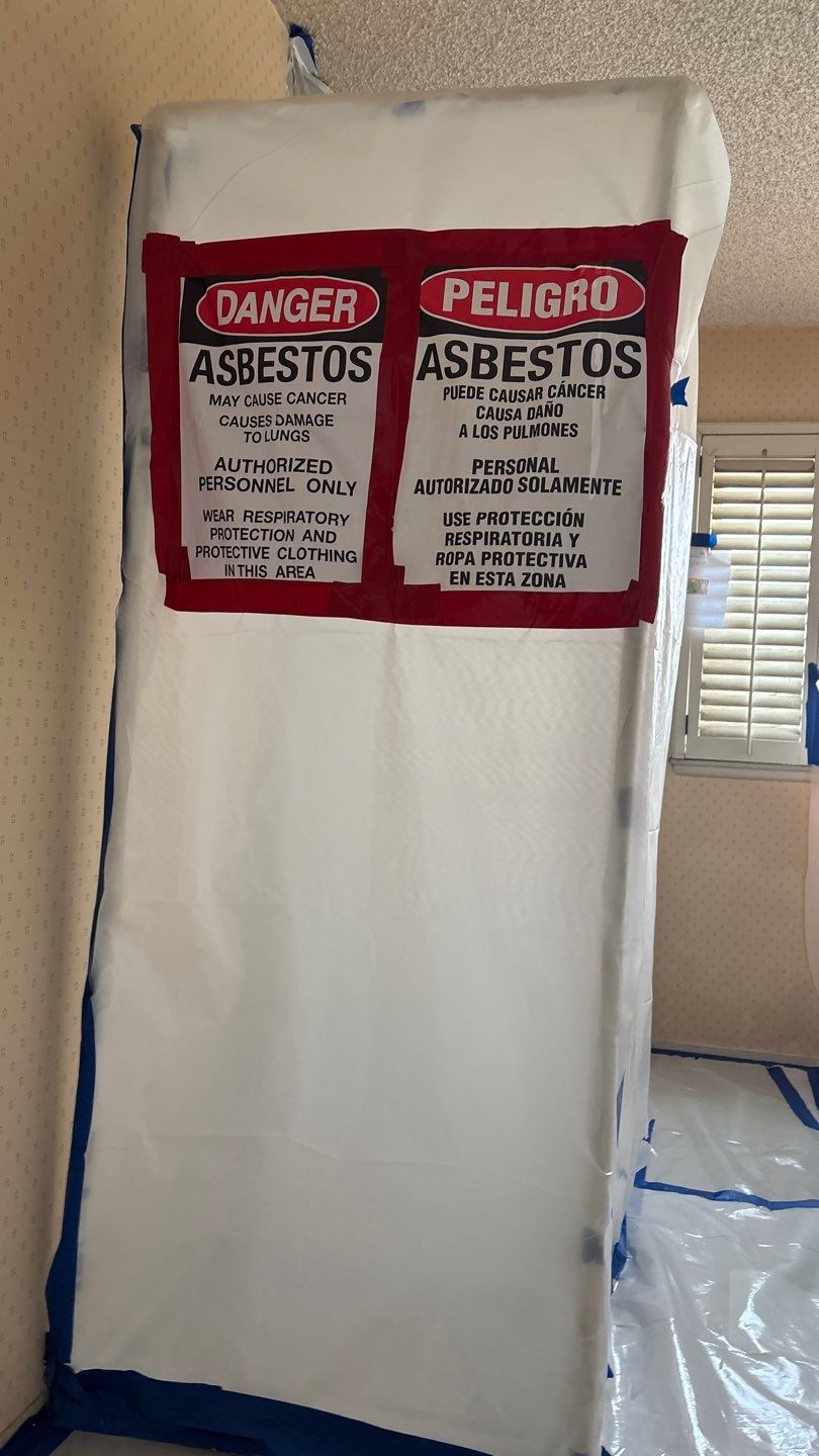 Asbestos warning signs on a sealed containment entrance at a VenTERRA project in Thousand Oaks